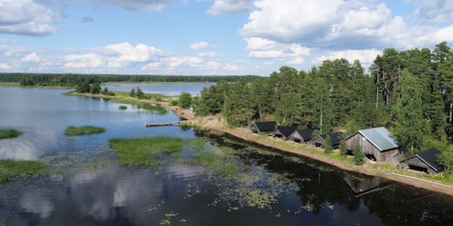 Meri, jonka edustalla salmi, jossa puisia A-rakenteisia rakennuksia.
