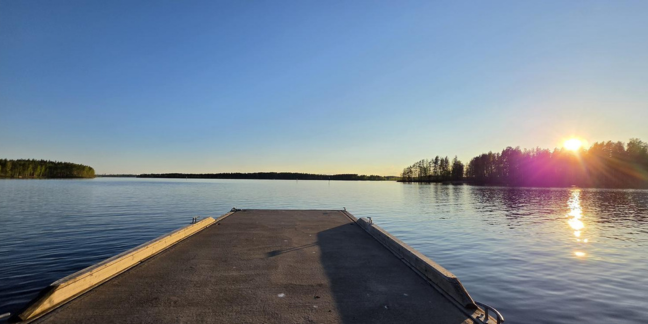 Vesistön edessä laituri ilta-auringossa.
