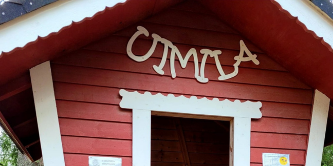 Punavalkoinen puinen pieni rakennus, jossa valkoisilla kirjaimilla tehty kyltti "Uimila".