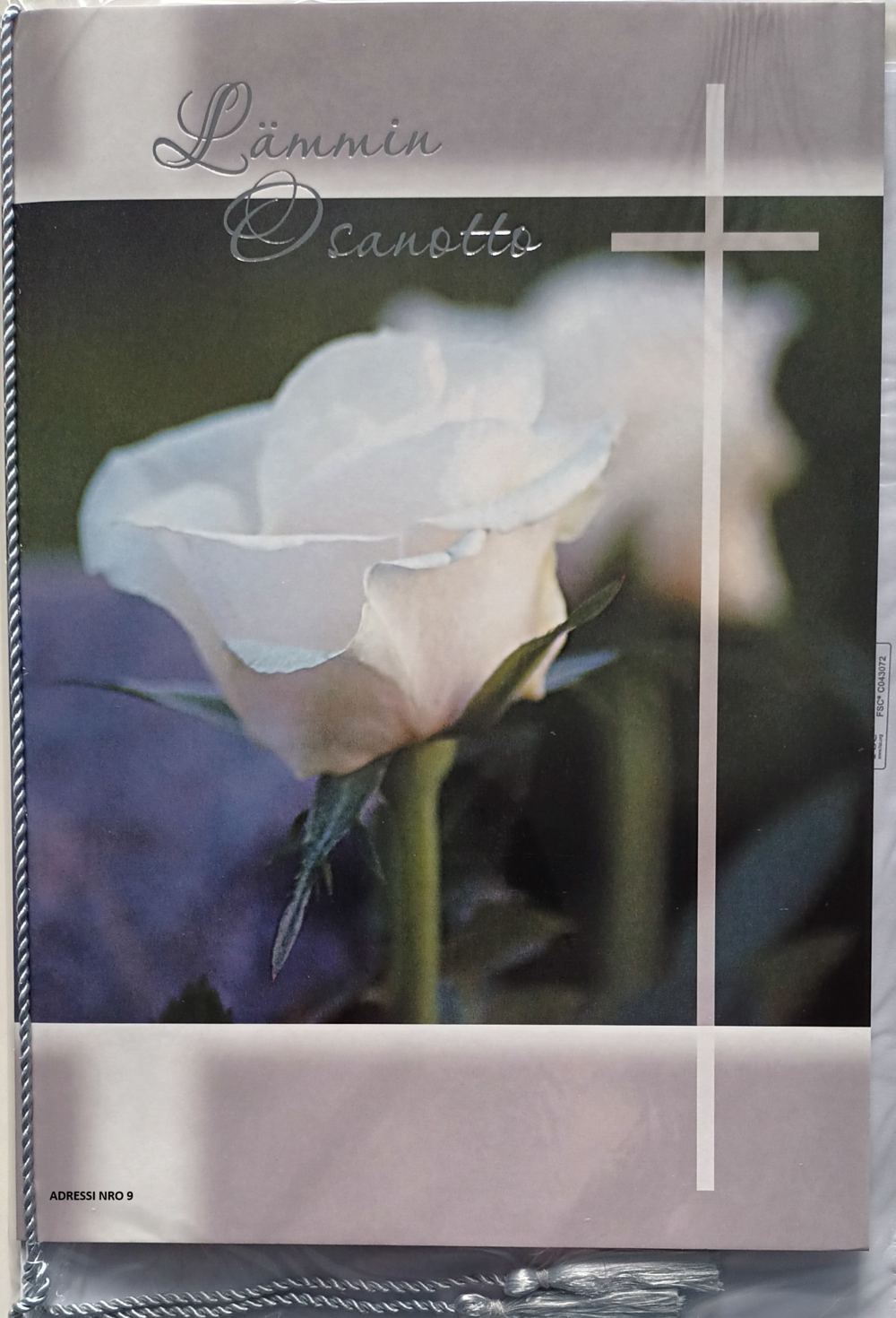 Adressi nro 9. Kuvassa risti ja valkoinen ruusu. Teksti Lämmin osanotto.
Kuva on linkki muistolauseisiin.