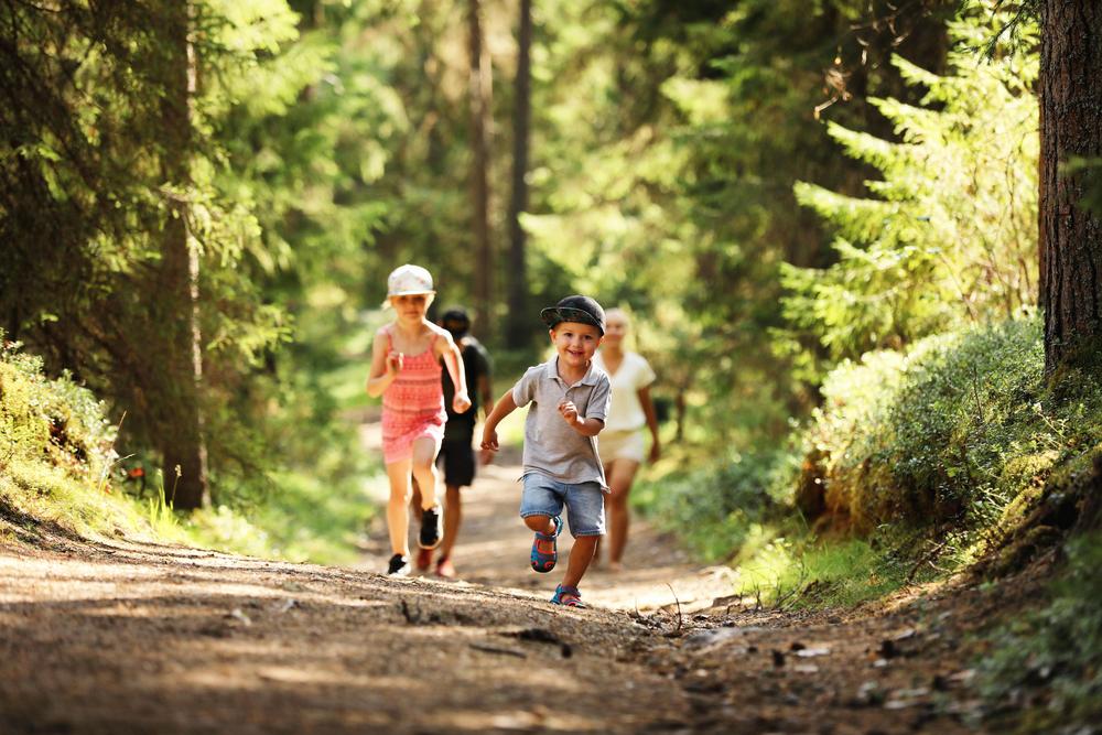 Lapset juoksevat metsässä
