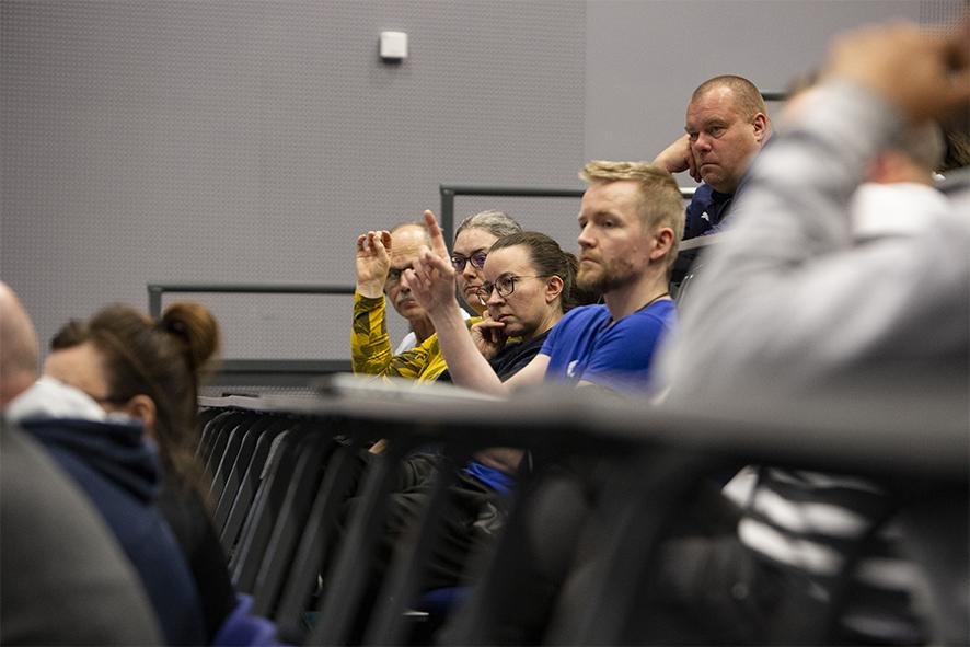 Oululaista urheiluseuraväkeä keskustelutilaisuudessa auditoriossa pyytämässä puheenvuoroa. 