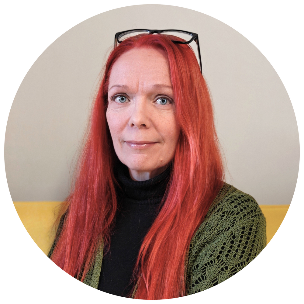 Toiminnanjohtaja Sanna Kalajanniska vaaleansinisessä takissa ja vaaleanpunaisessa kaulahuivissa.