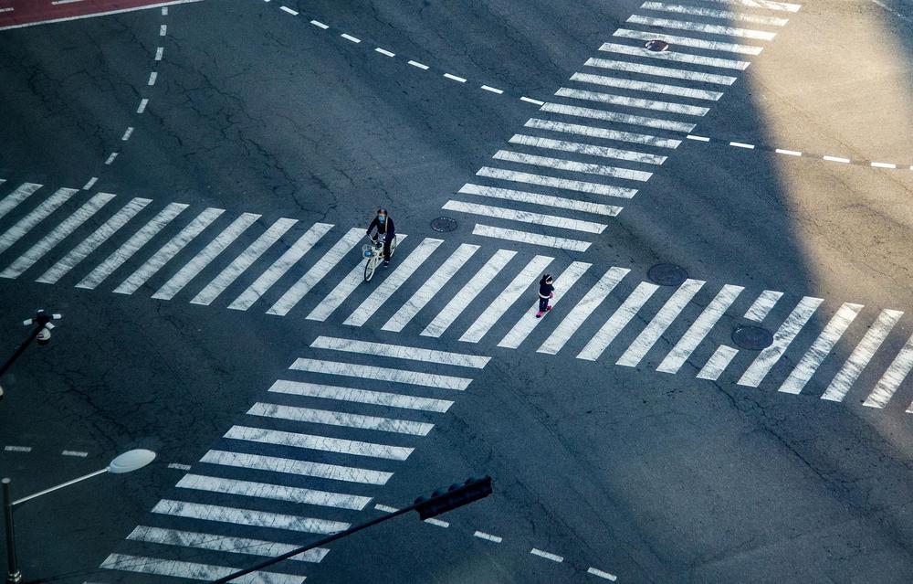 risteysalue kuvattuna ylhäältä, jossa suojatiet risteävät keskellä risteystä ja kaksi pientä hahmoa on suojatiellä.