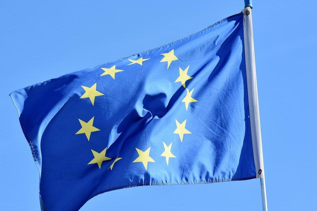 Lähikuva EU-lipusta, joka liehuu tangossa sinistä taivasta vasten.