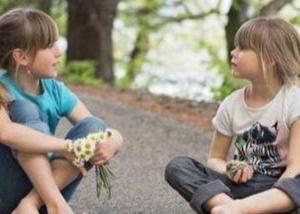 Lapset istuvat hiekkapolulla ja keskustelevat menisivätkö savityö-, piirustus- vai liikuntakurssille.