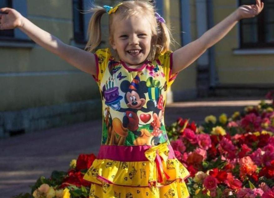 Lapsi riemuitsee kukkien edessä kurssille mennessään