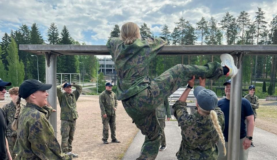 Varushenkilöitä kuvassa: yksi varushenkilö ylittää korkealla olevaa puomia