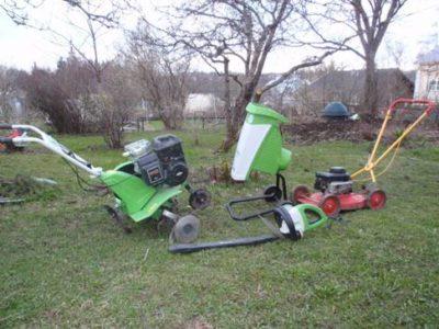 Erilaisia puutarhanhoitoon tarkoitettuja koneita aseteltuna nurmikolle. 