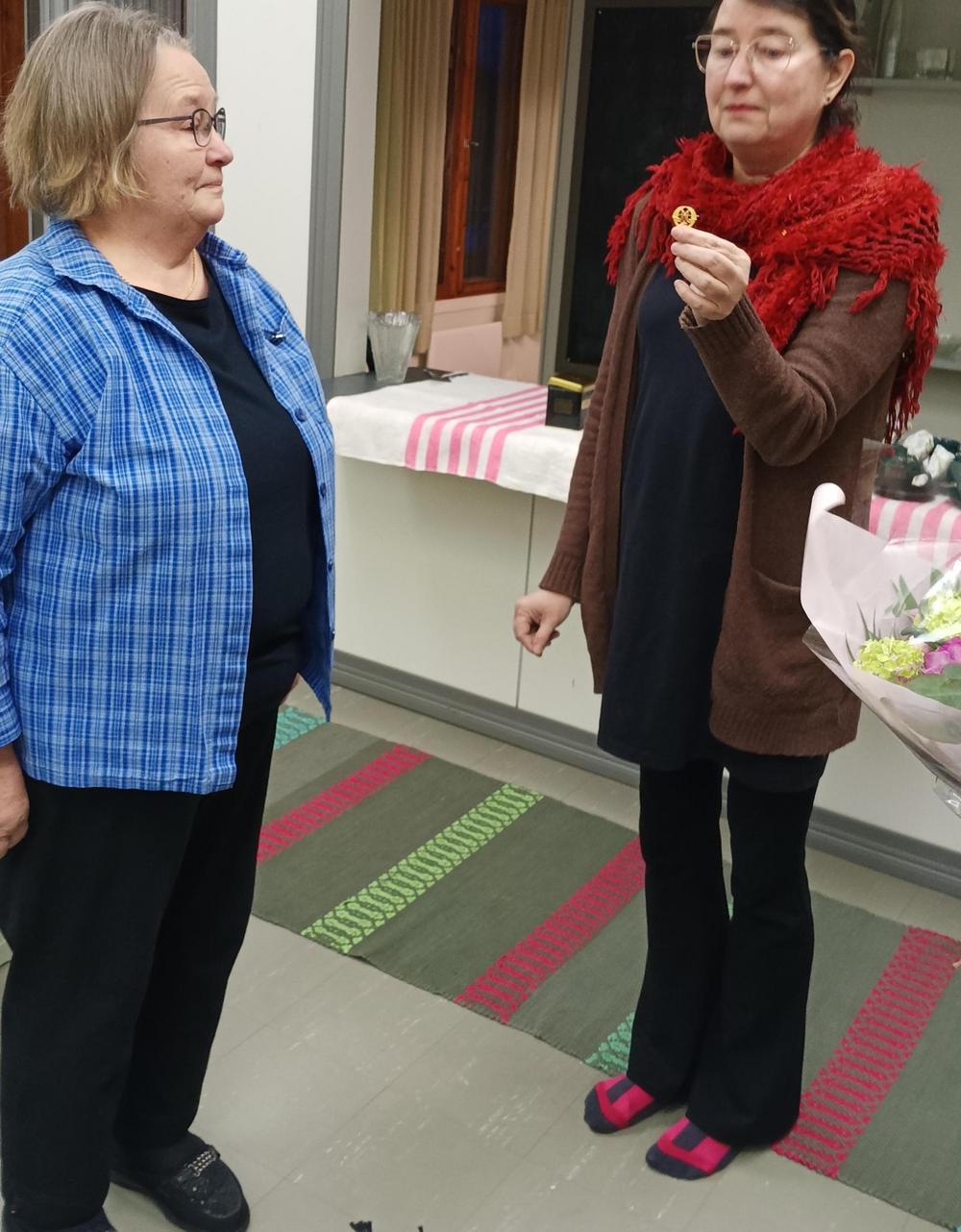 Puheenjohtaja Leila Laaksolle ojennetaan 50-vuotismerkkiä sihteeri Kirsi Ritolan toimesta. 