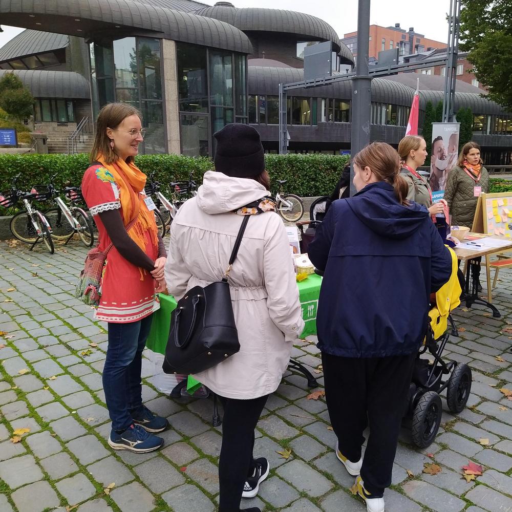 Neuvojamme ja pöytä, jossa on yhdistystoiminnan esitteitä ja allergiaoppaita sekä ihmisiä juttelemassa.