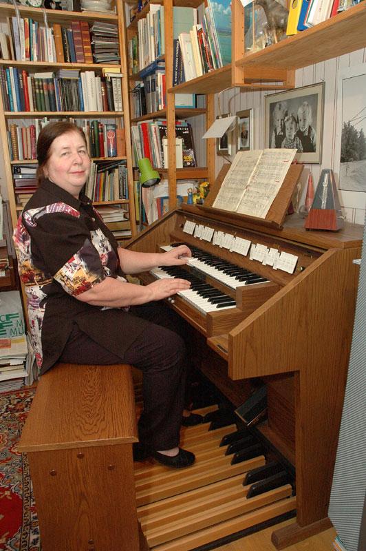 Nainen soittamassa urkuharmoonia