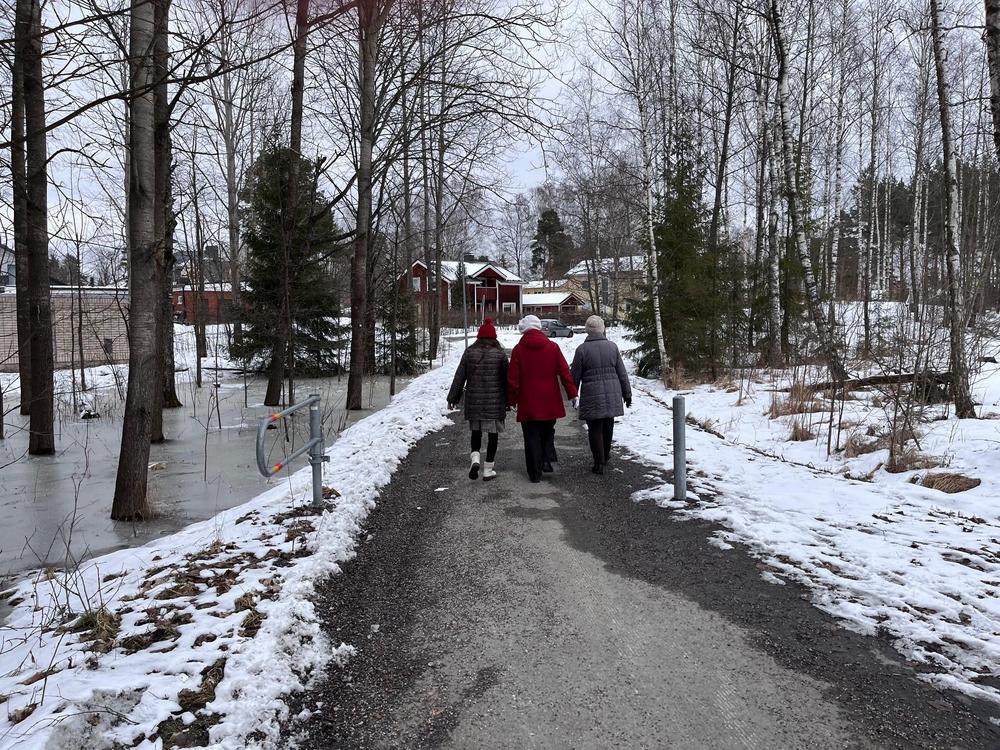 Kolme ulkoilijaa, luminen maisema