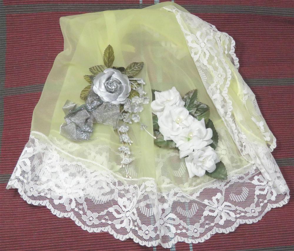 Pitsinen kangas jonka päällä on kukkasista tehtyjä hiuskoristeita