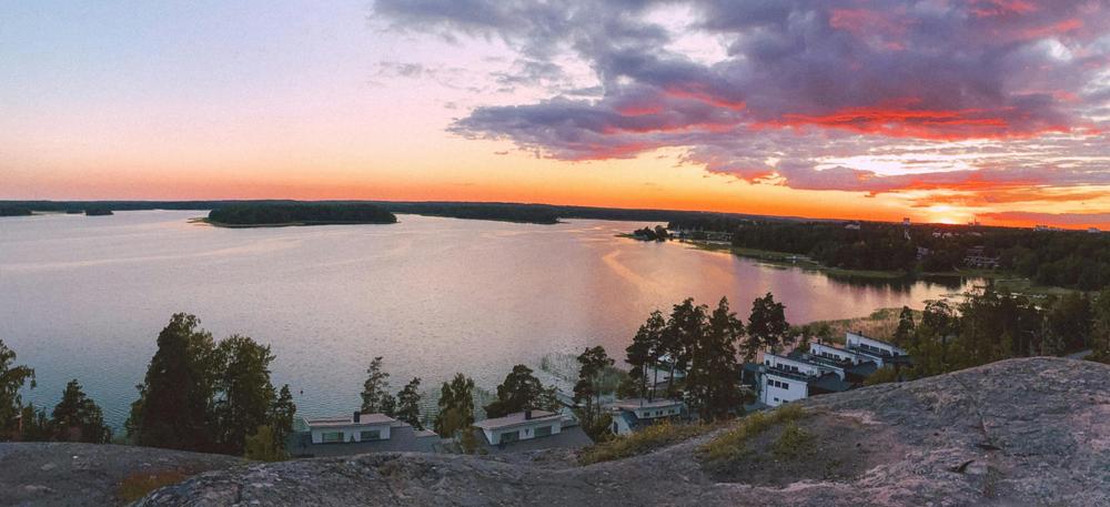 Merinäköala, joka on kuvattu Soukasta, Kasavuoren päältä. Edessä on sileitä graniittikallioita, kauampana merenlahti ja saaria ilta-auringossa.