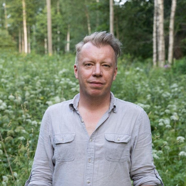 Petri Tiainen Tomi Palsan ottamassa kuvassa. Taustalla mesiangervoja ja koivikko.