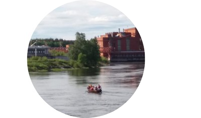 Kymijoki, jonka taustalla paperitehdas ja joessa soutuvene.