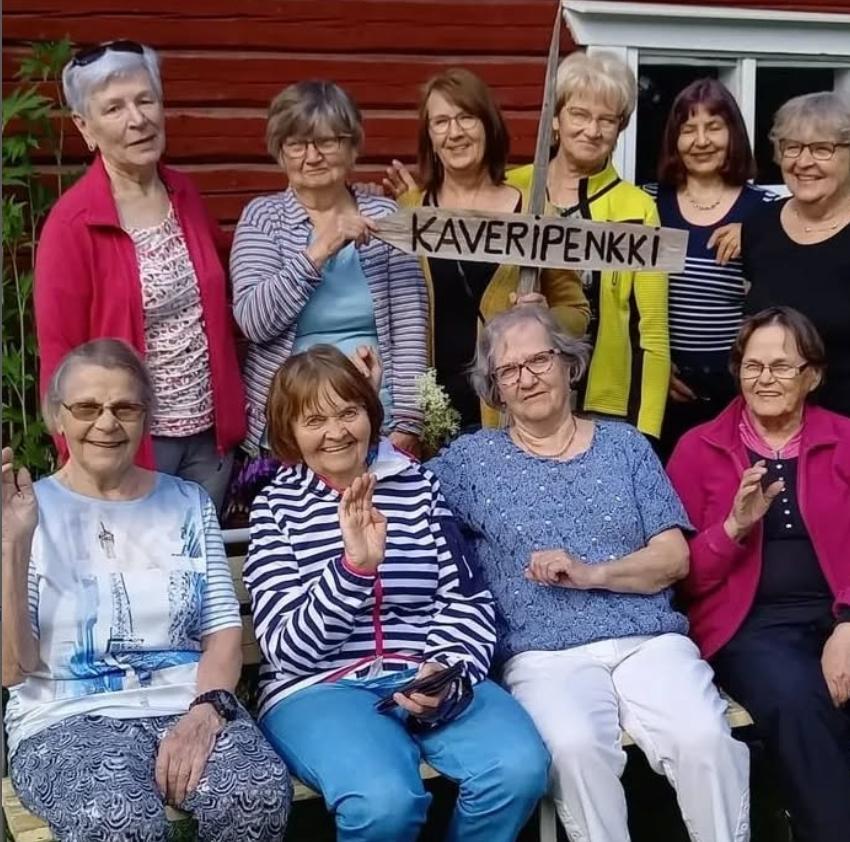 Kuvassa on kymmenen vapaaehtoista. Kesäinen kuva ulkoa otettu.