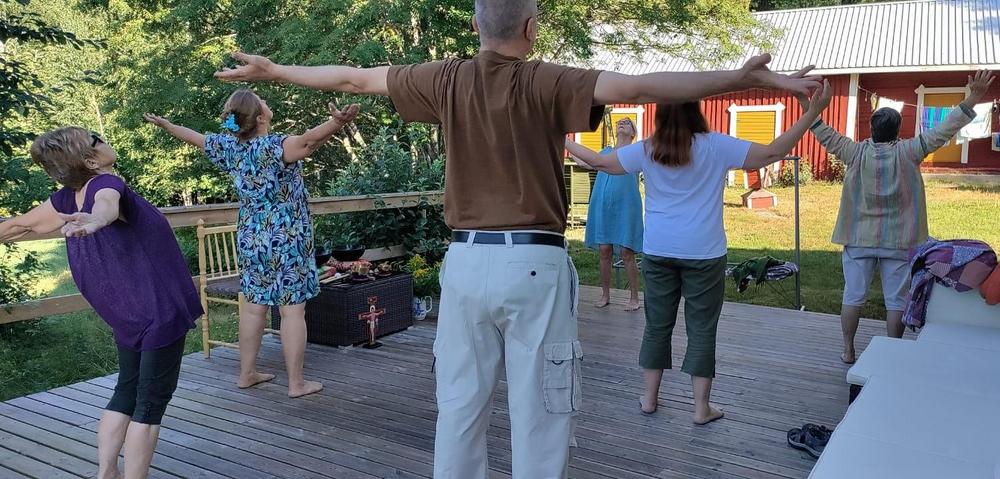 Henkilöt venyttelevät talon terassilla.
